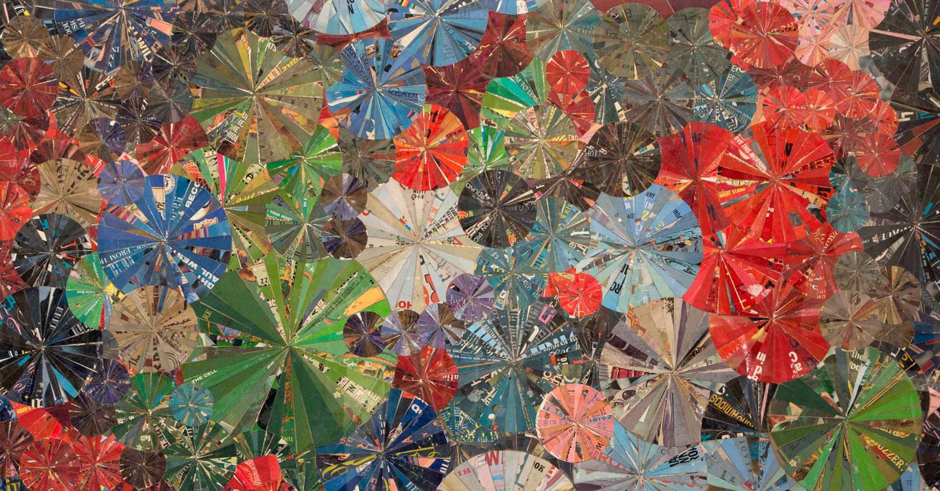 Radiating paper-collage artwork of layered pinwheel and floral forms in reds, blues, and greens, from the firm's collection